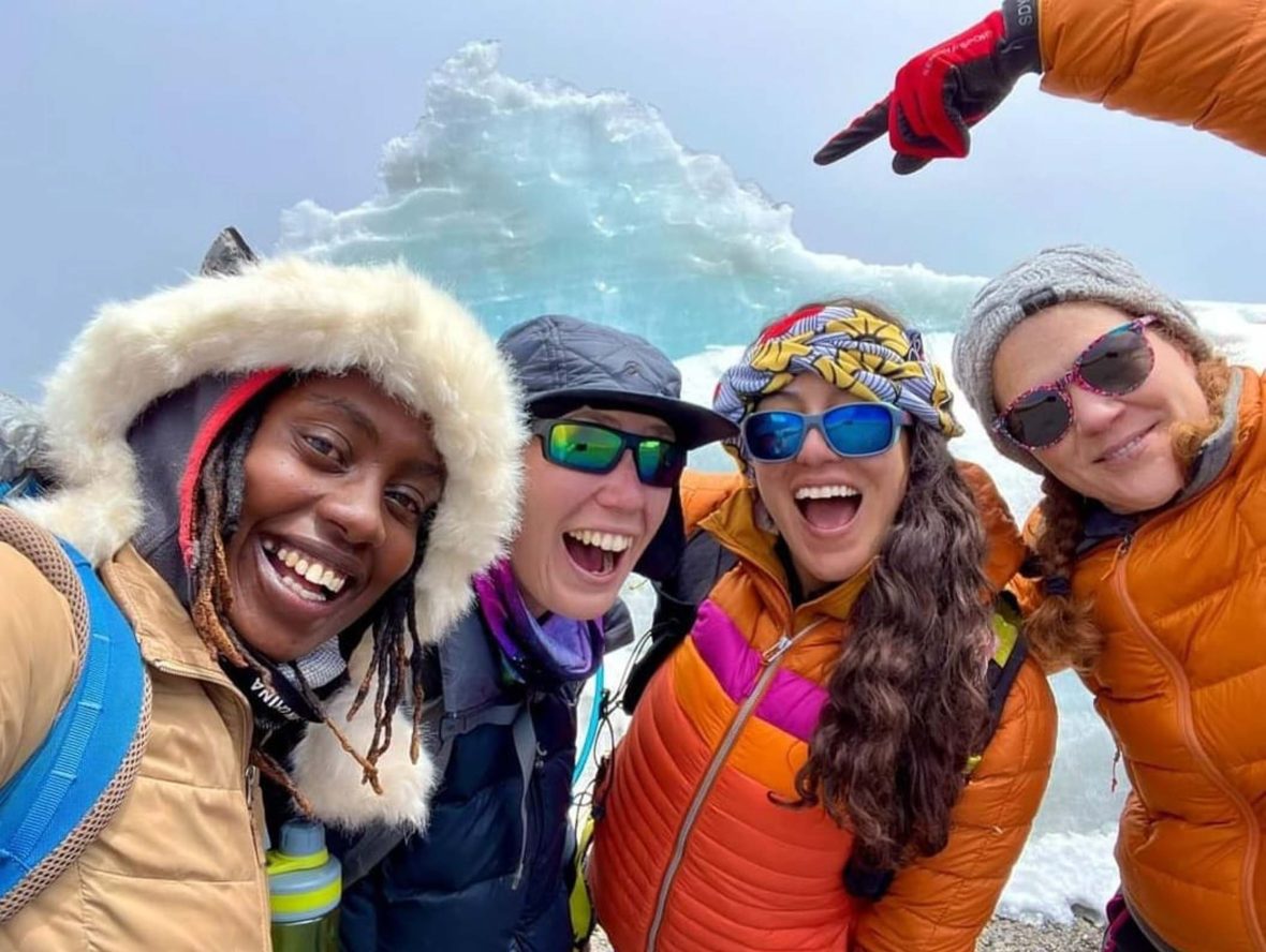 The guide and three tourists smile to the camera.
